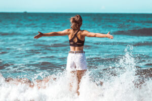 nothing is impossible. Woman facing large waves on a beach