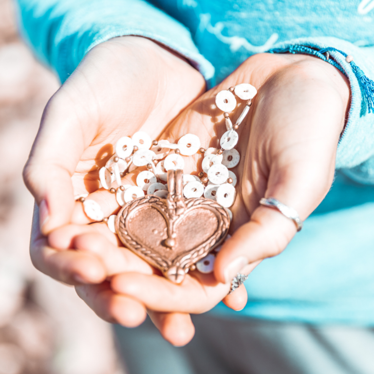 Holding a heart pendant necklace in hands to symbol lets connect